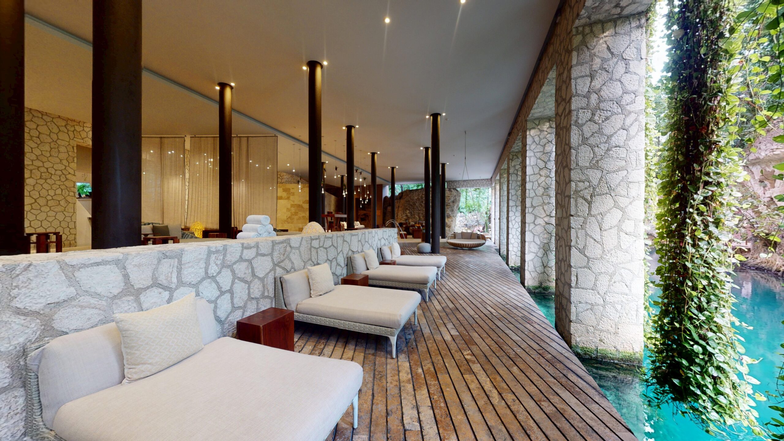 Muluk Spa relaxation deck with loungers beside the turquoise river at Hotel Xcaret México