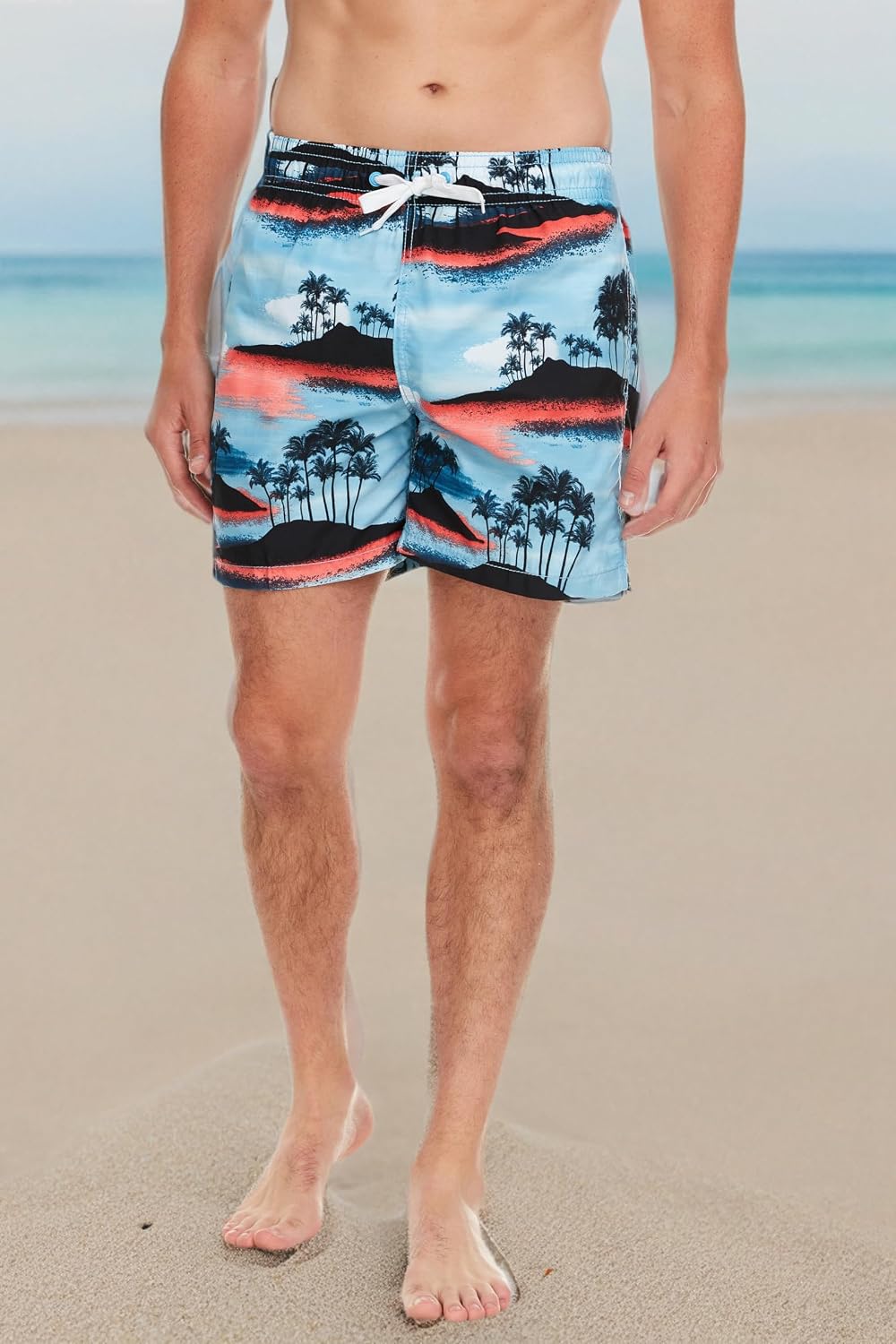 Kanu Surf swim trunks in the Islands Blue/Coral print worn on the beach