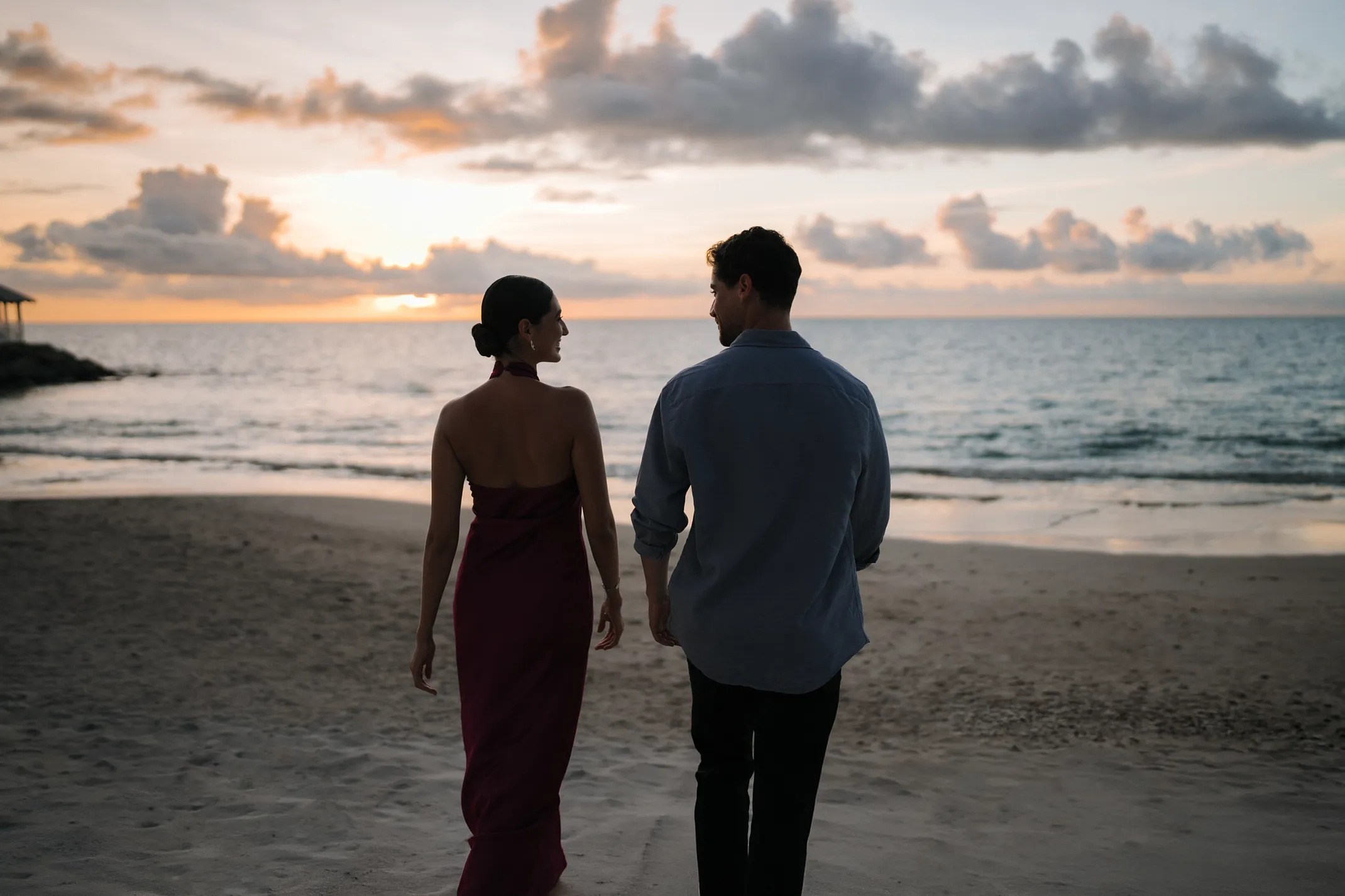 A couple walking the calm, palm-lined beach on Choc Bay at Secrets St. Lucia