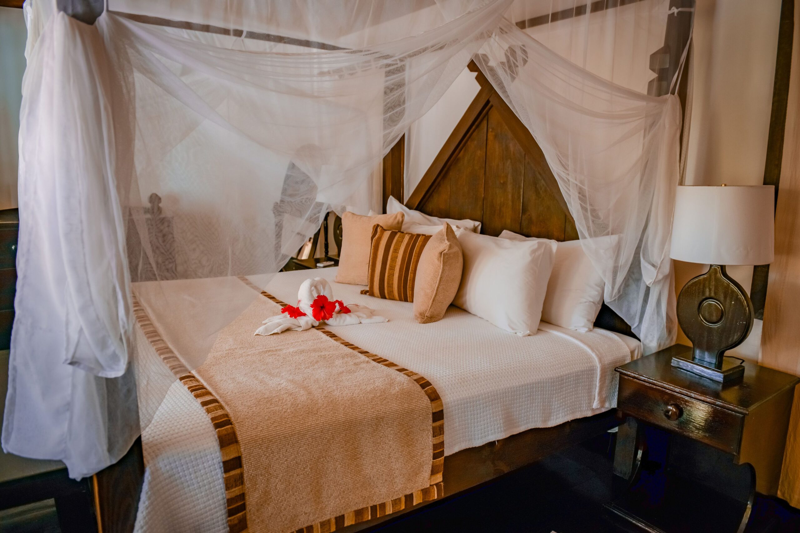A cottage interior with a king four-poster bed at Cocos Hotel Antigua