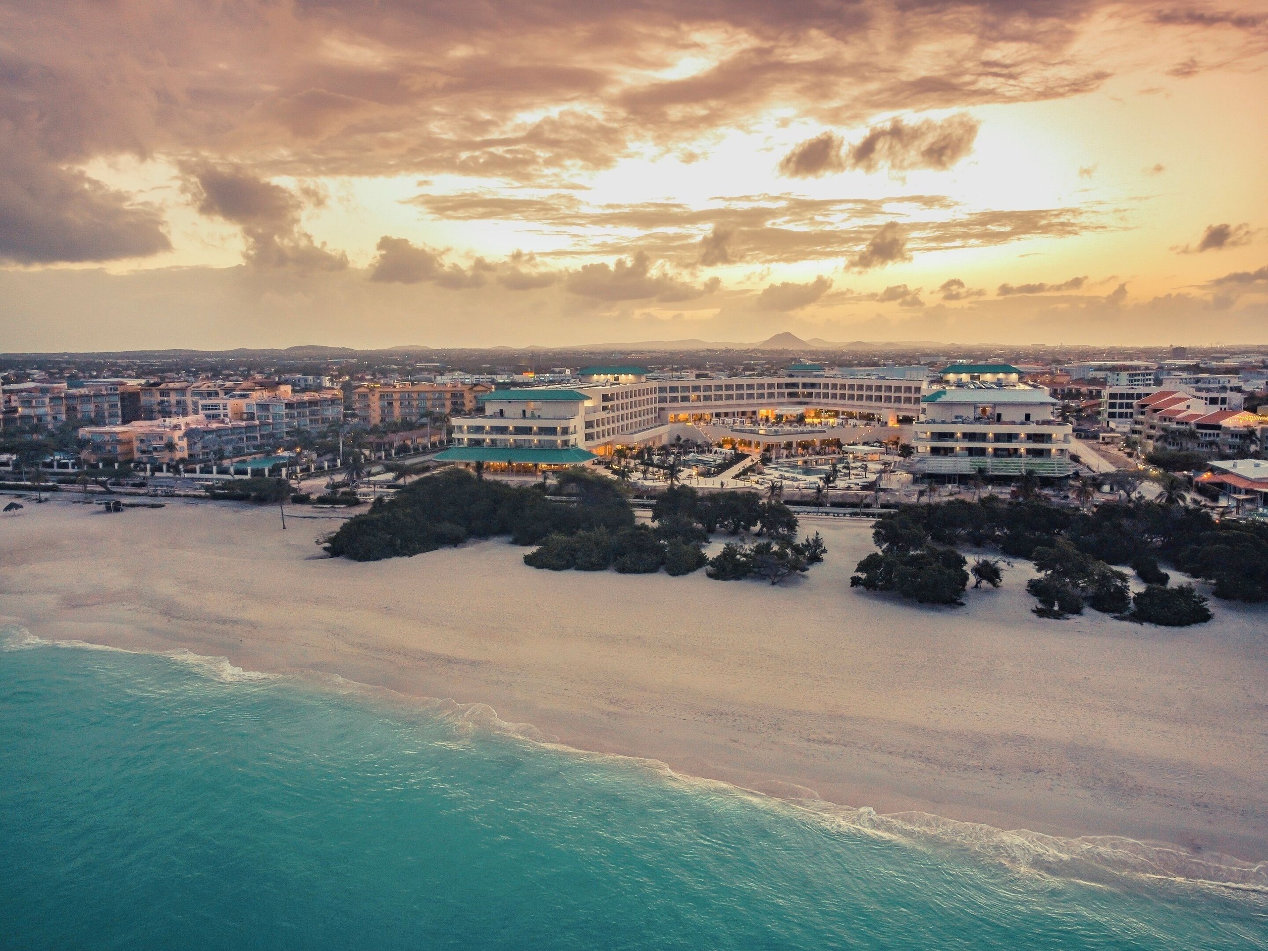 Aerial view of Eagle Beach with JOIA Aruba by Iberostar set back behind the treeline