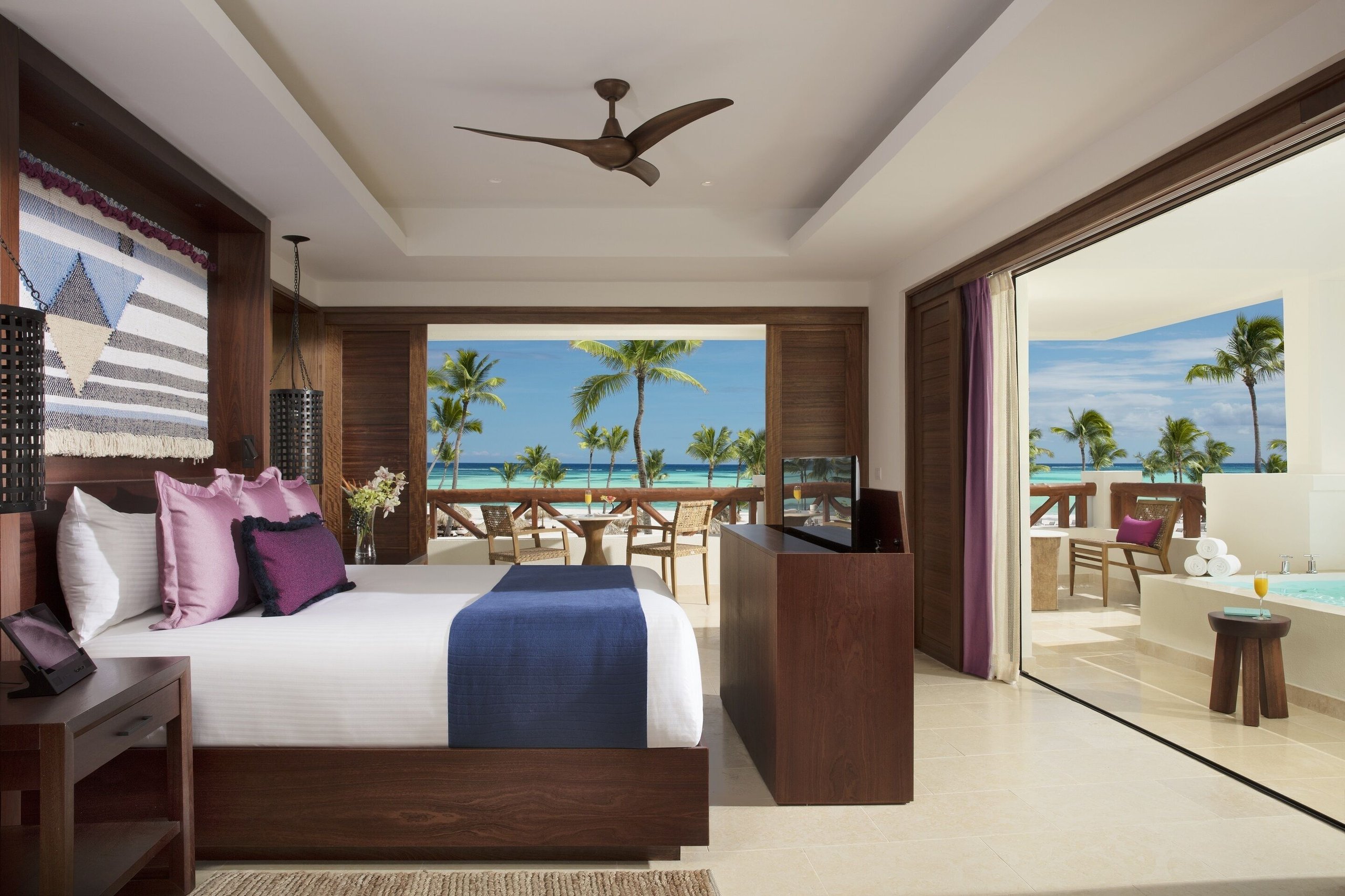 Ocean-view suite at Secrets Cap Cana with a king bed, balcony seating, and terrace jacuzzi overlooking the sea