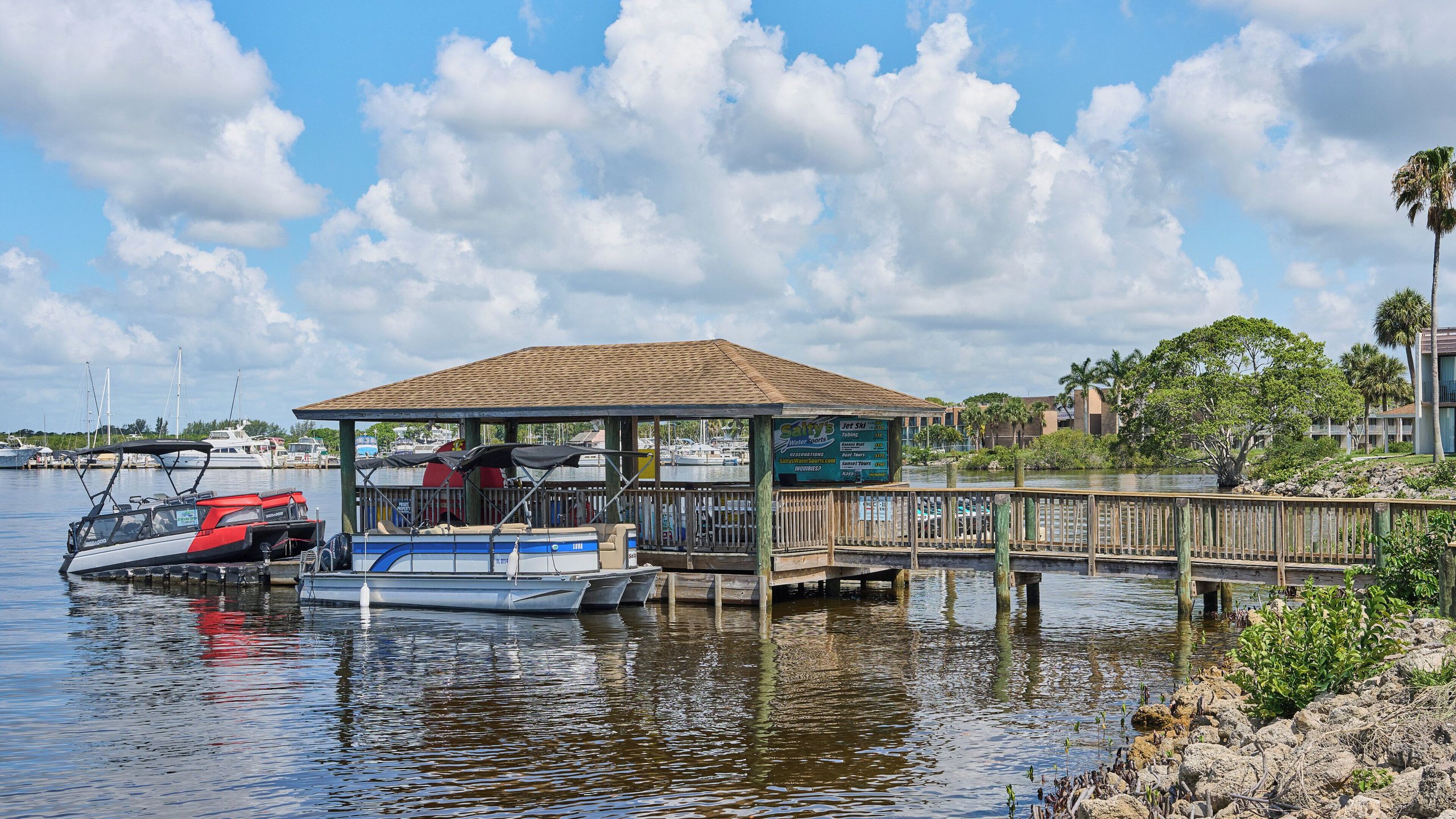 Pontoon boats docked at the voco Sandpiper marina pavilion on the St. Lucie River