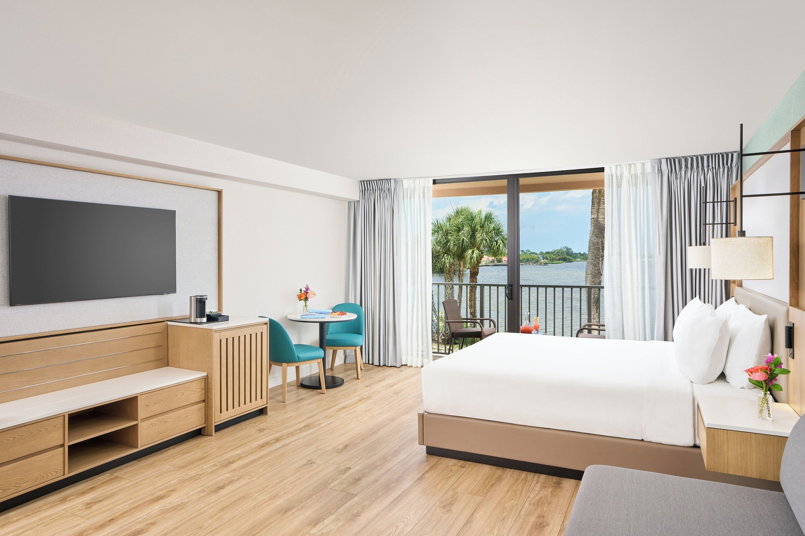 King room at voco Sandpiper All-Inclusive Resort with modern furnishings and a balcony overlooking the St. Lucie River