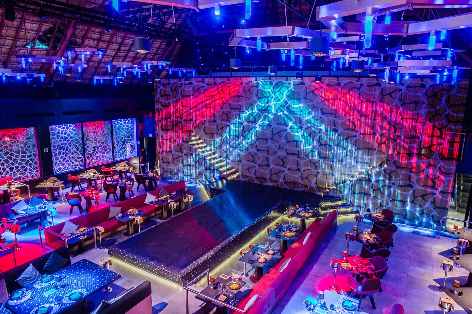 Rauxa, the dinner-and-show venue, with the stage lit and tables around it