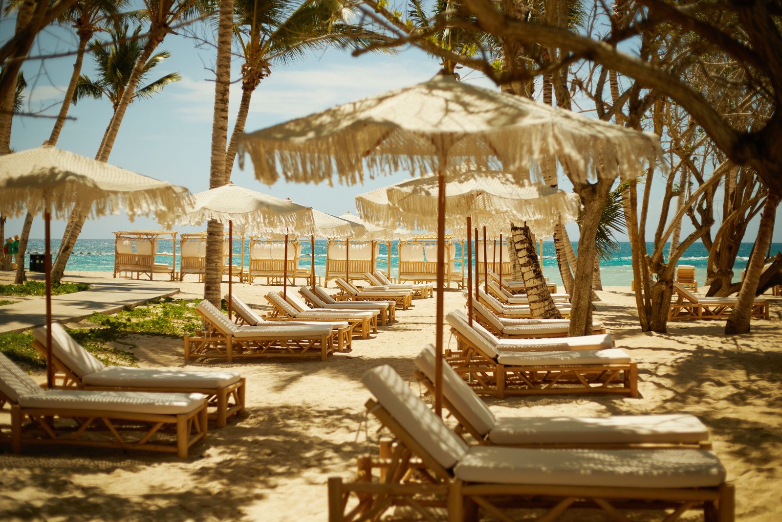 Rows of wooden loungers and fringed umbrellas on the beach at Cayo Levantado Resort