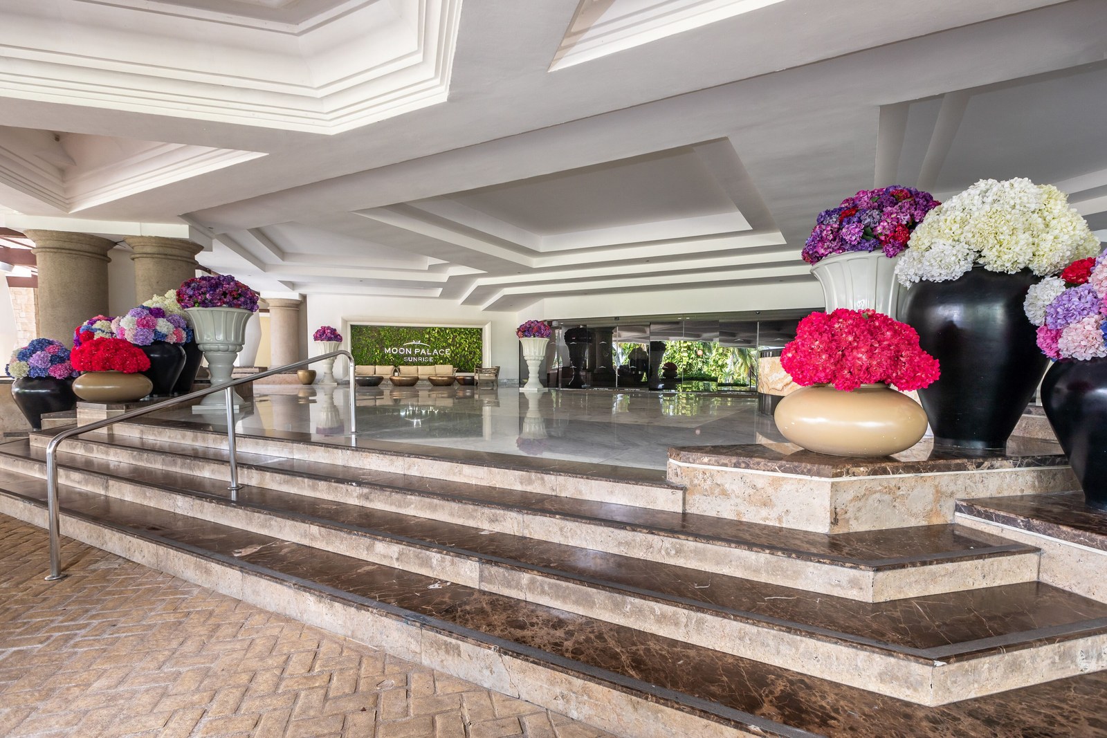 The marble lobby at Moon Palace Cancún with flower arrangements on the steps