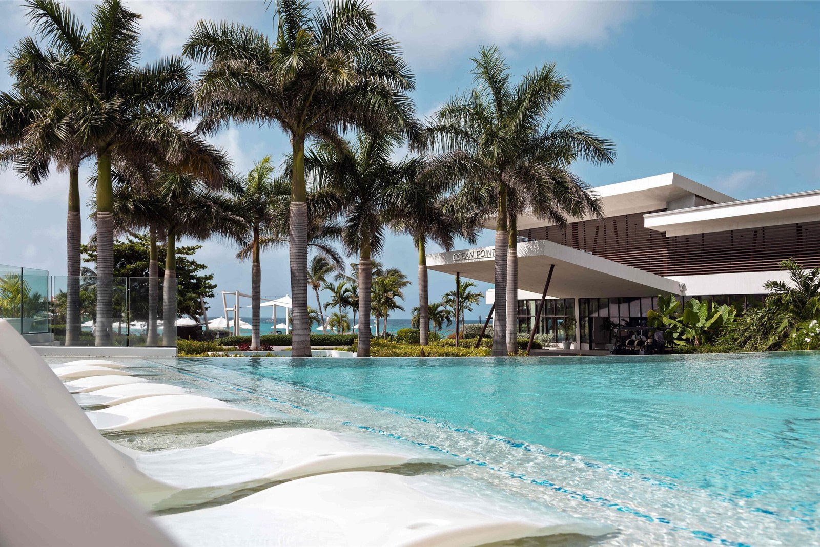 The Seascape pool at Sonesta Ocean Point with loungers set in the water and palm trees behind