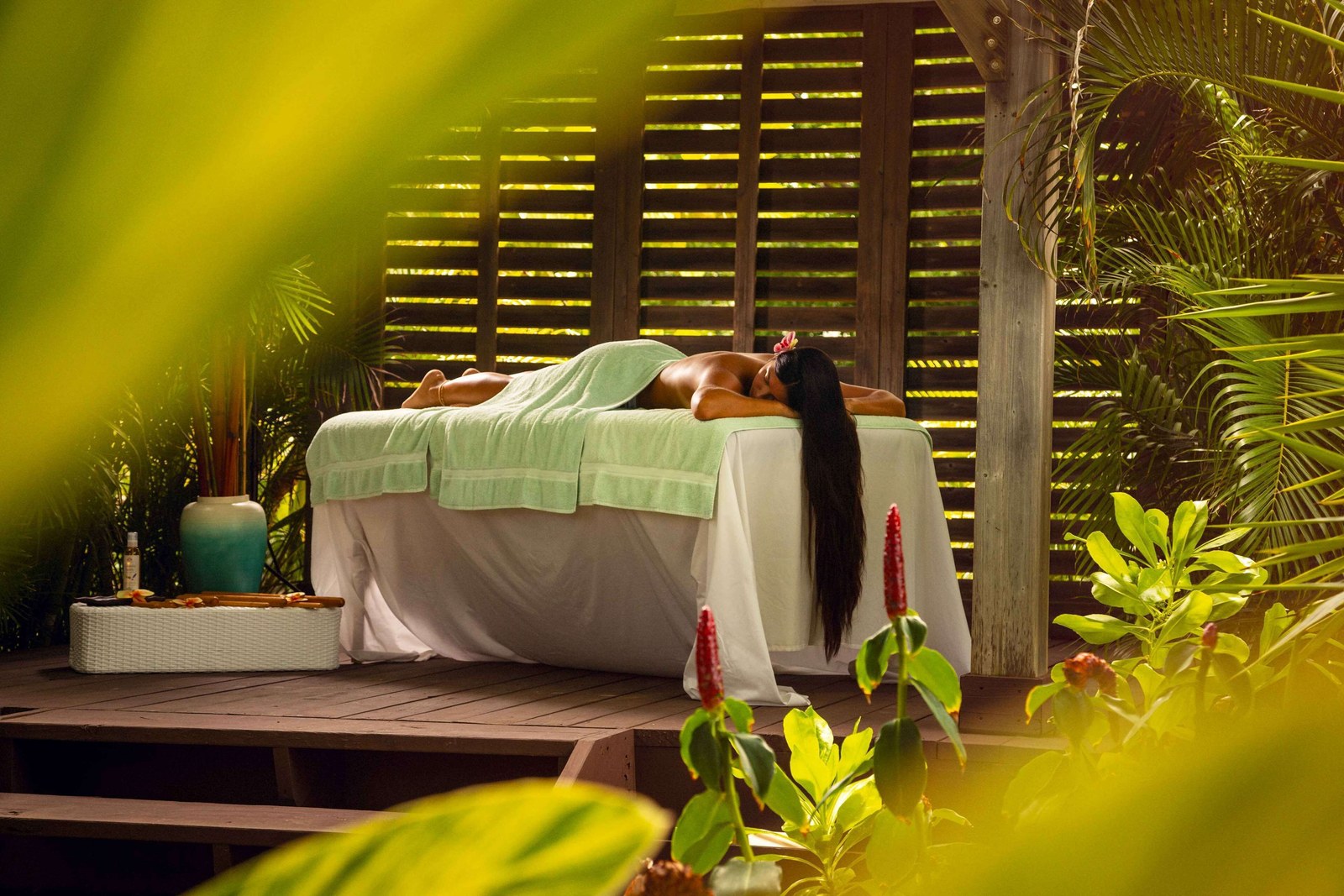 A guest having a massage in the open-air spa gazebo at Sonesta Ocean Point, surrounded by greenery