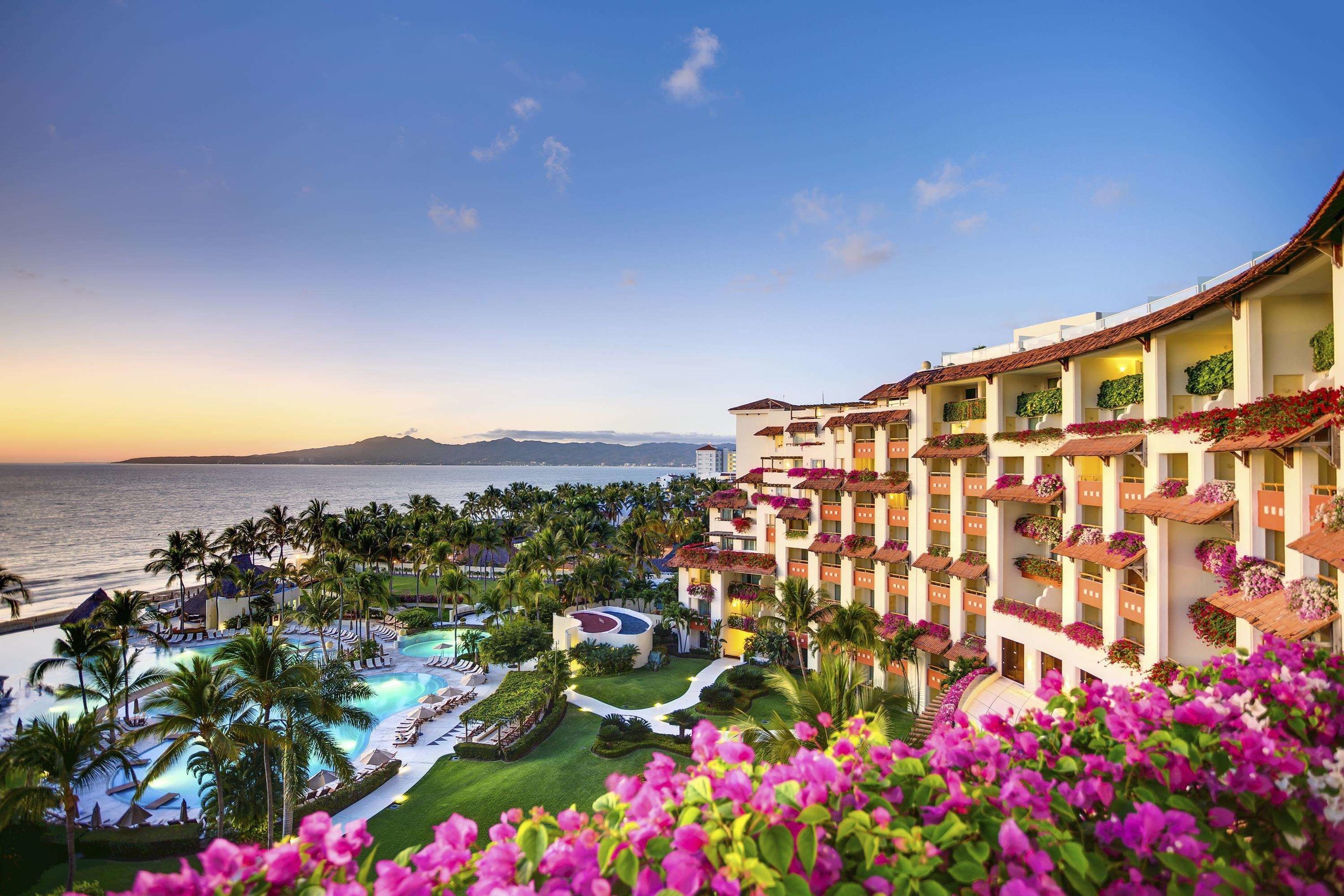 Grand Velas Riviera Nayarit's hotel wings and gardens above the bay at sunset