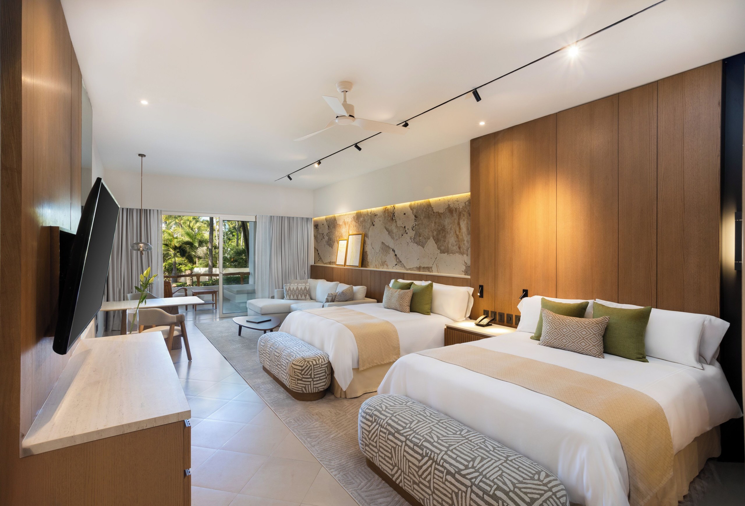 A suite at Grand Velas Riviera Nayarit with two beds, light wood and a large window
